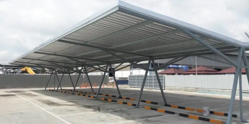 Large steel car parking shed with marked bays at a facility